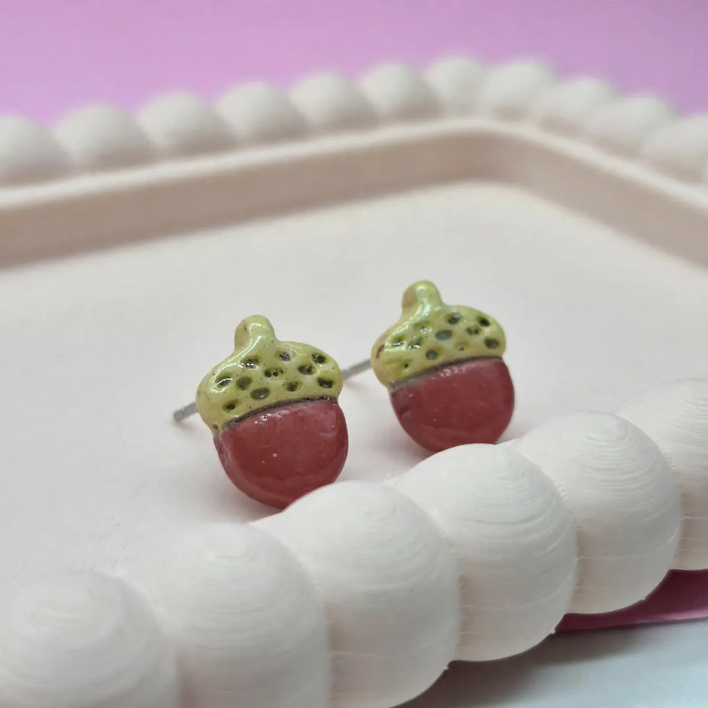 Gros plan sur deux puces d’oreilles gland en argile, chapeau vert clair et corps terracotta