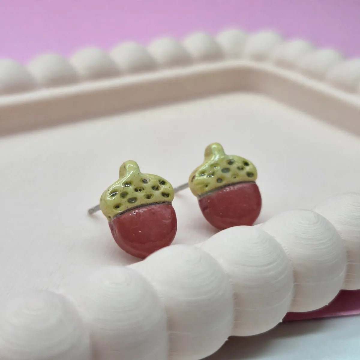 Gros plan sur deux puces d’oreilles gland en argile, chapeau vert clair et corps terracotta