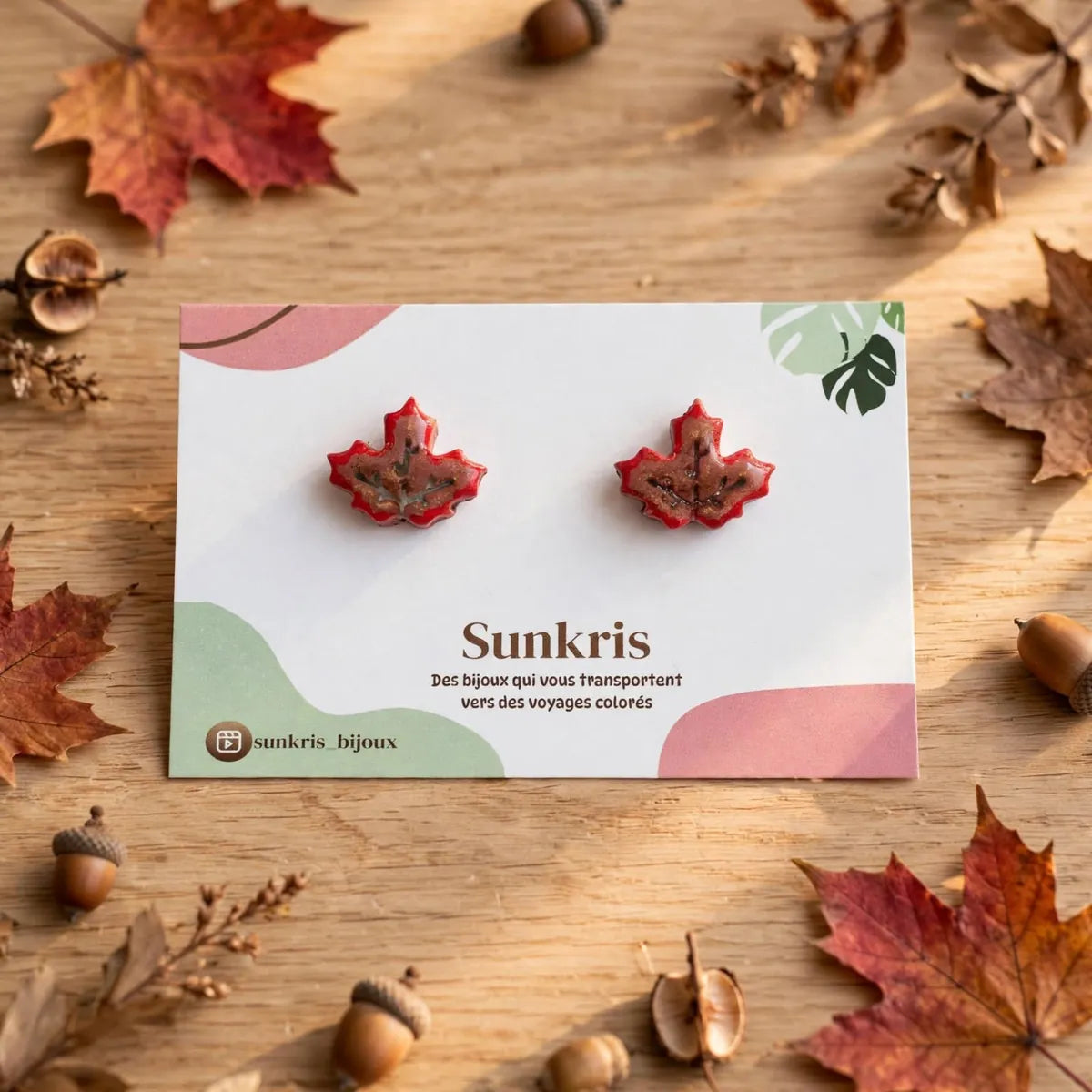 Puces d’oreilles feuille d’érable rouge sur une carte Sunkris entourée de feuilles d’automne et de glands