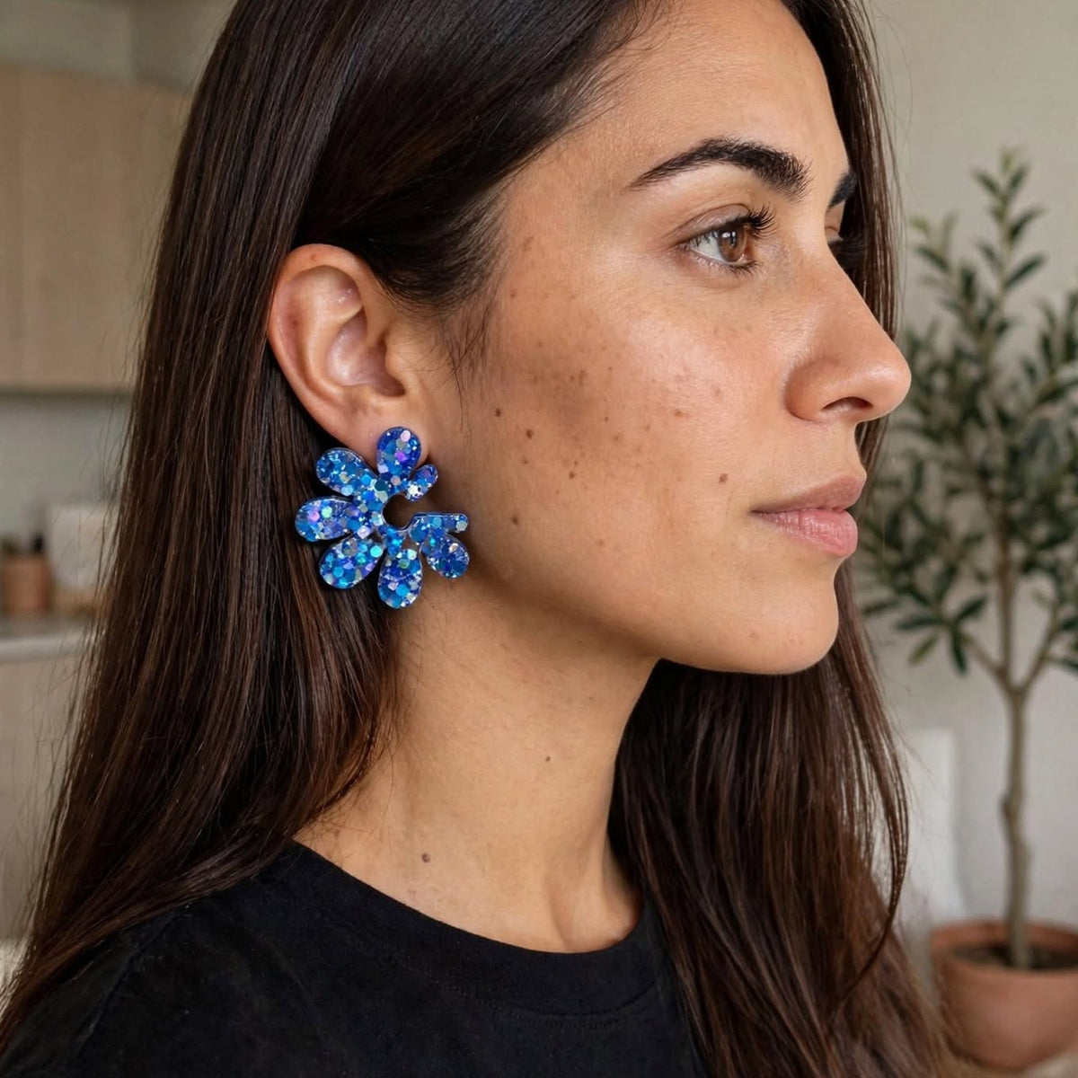 Boucles d’oreilles fleur bleu pailletées en résine, bijou artisanal SunKris porté sur une femme de profil