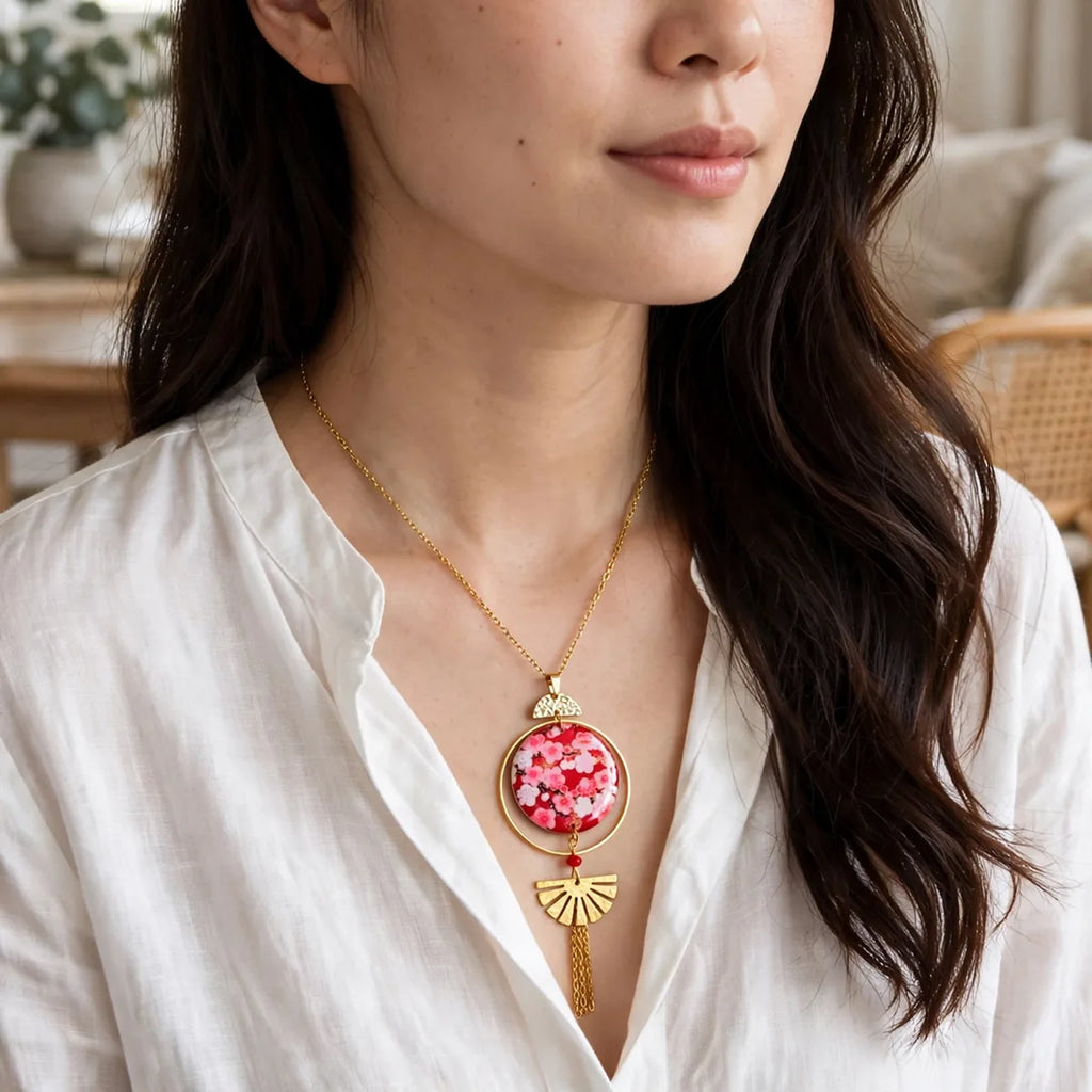Femme portant le collier Sakura Sunkris, chemise blanche, gros plan pendentif fleur de cerisier